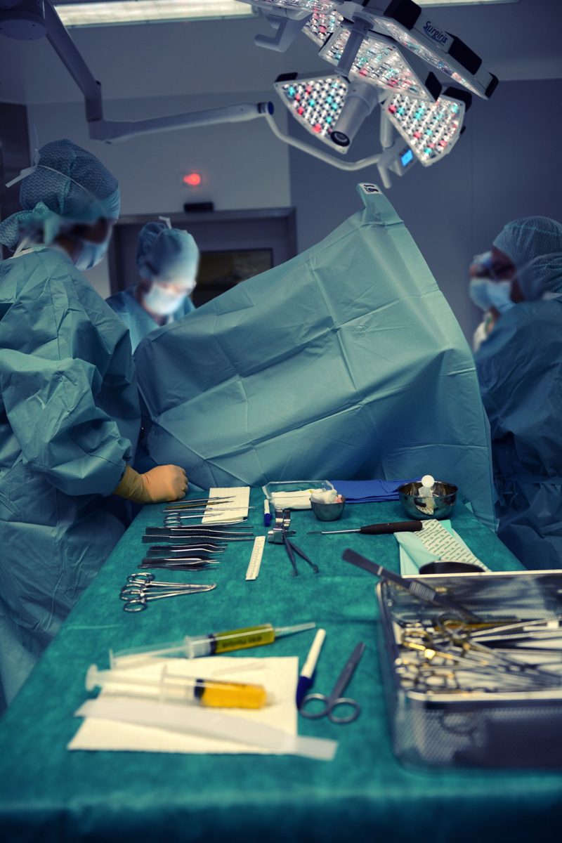 Surgical team in an operating room with an instrument table